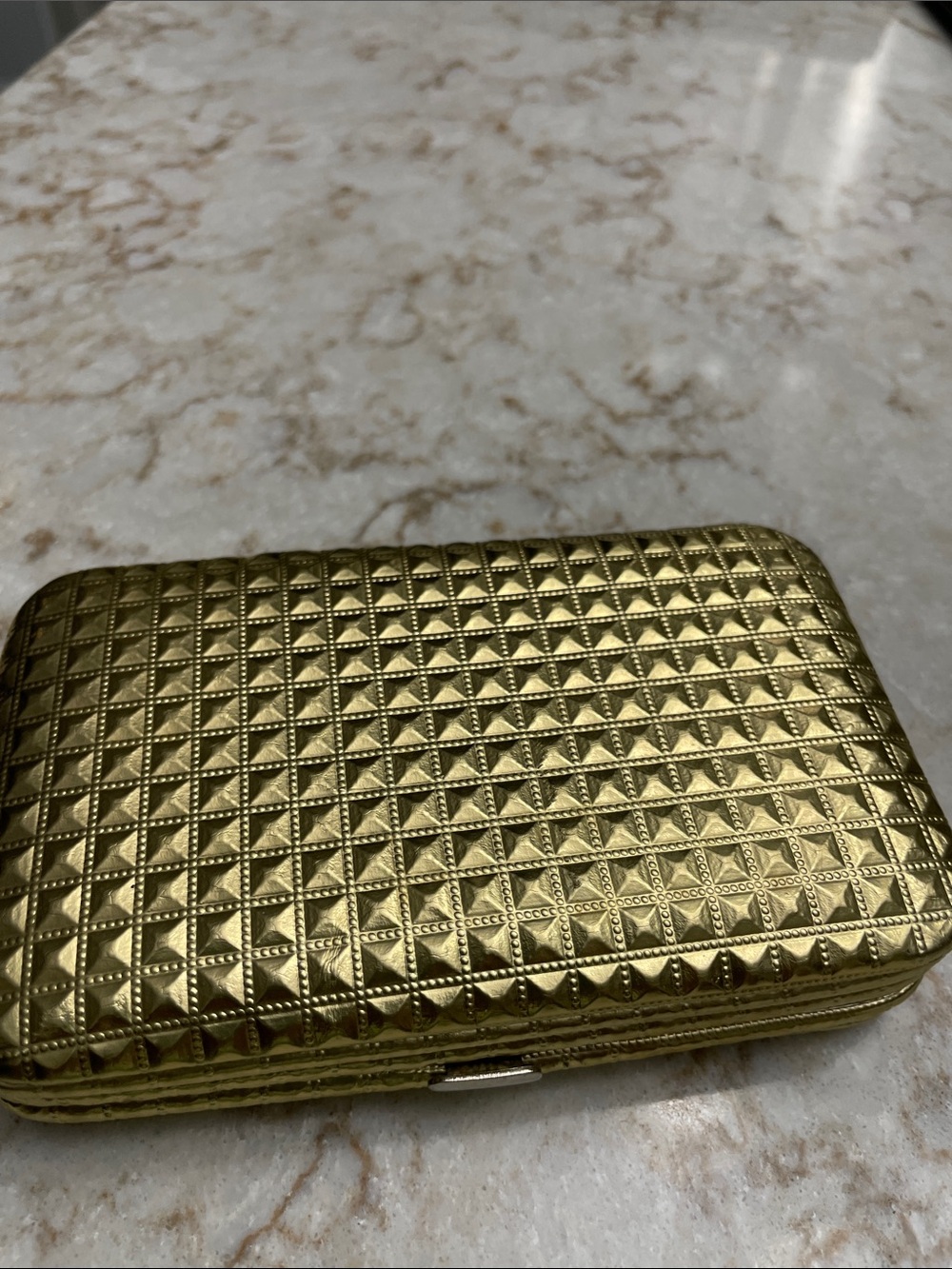 Gold credit card Or Identification holder and small phone . And a handle.